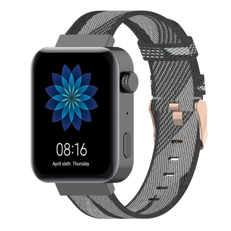Grey and black striped nylon watch band with buckle and pin holes.