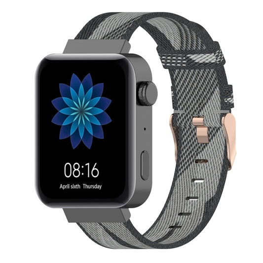 Grey and black striped nylon watch band with buckle and pin holes.