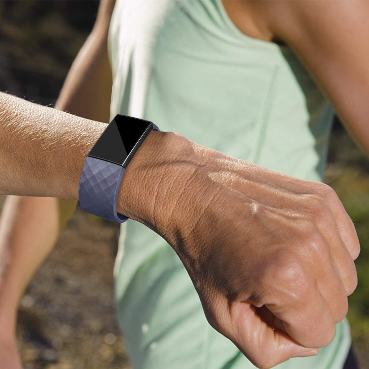 Adjustable sport watch band on wrist, dark blue diamond-pattern strap with metal buckle