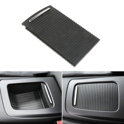Black ribbed center console cup holder cover with silver handle slot