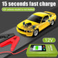 Green 12V jump starter connected to red clamps beside a yellow car