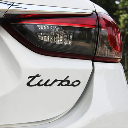 Black "turbo" decorative car sticker, applied on rear panel of a white car