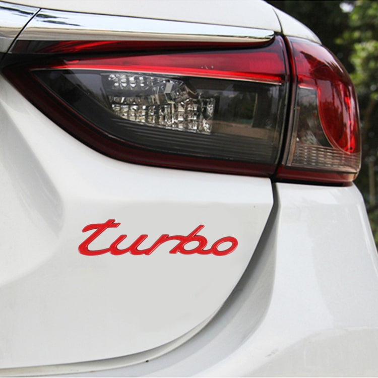 Red "turbo" decorative car sticker applied on rear panel of a white car