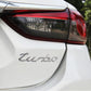 Silver "turbo" decorative car sticker applied on rear panel of a white car