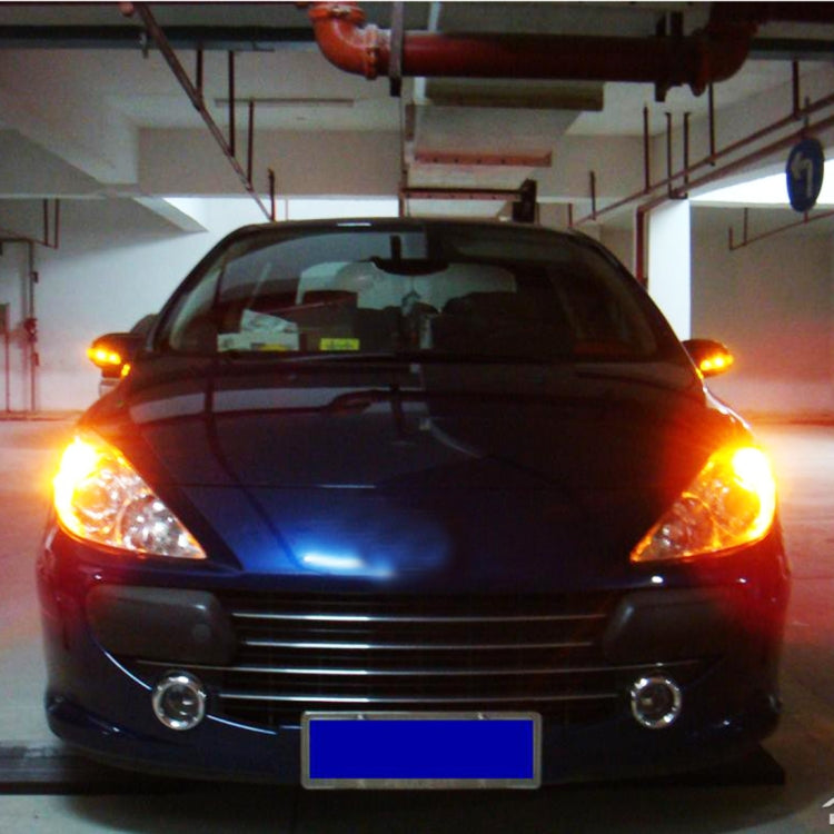 Car front with bright amber turn light LEDs on, headlights and grille visible