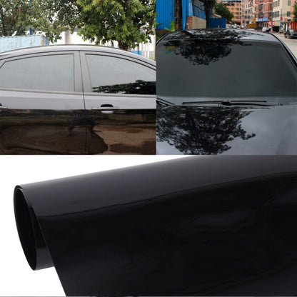 Car window tint film with dark, glossy finish applied to a sedan side window