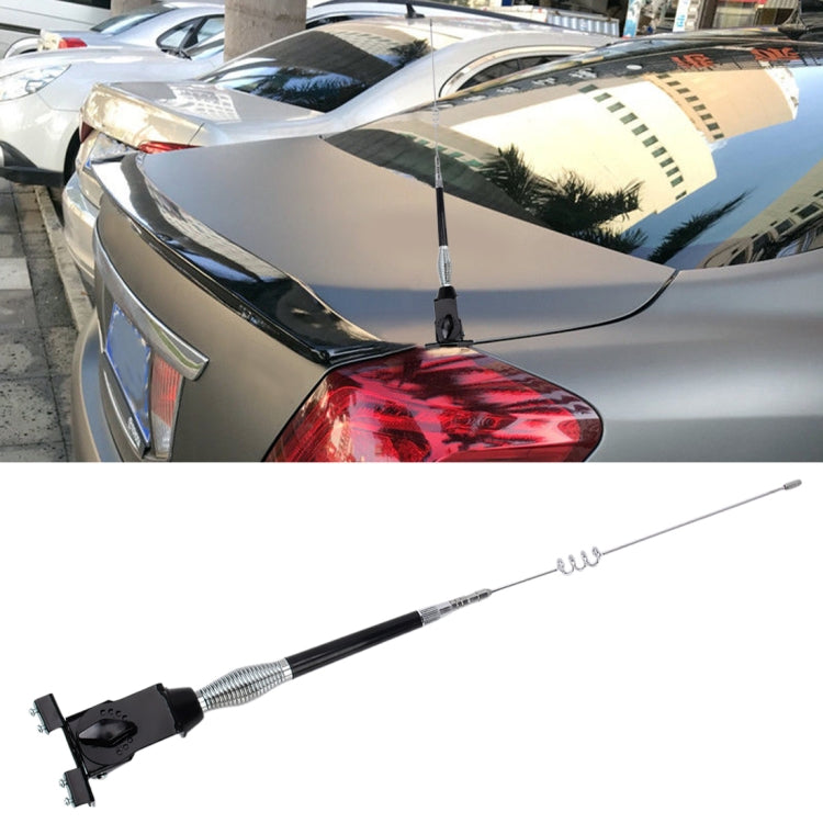Glass-mount cellular antenna with black rod and silver coil, mounted on car