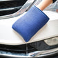 Blue microfiber car washer glove with cuff, pressing against vehicle body for wash
