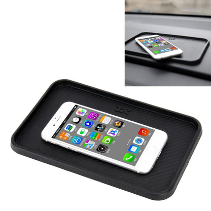 Black anti-slip rubber car tray mat with textured surface holding a smartphone