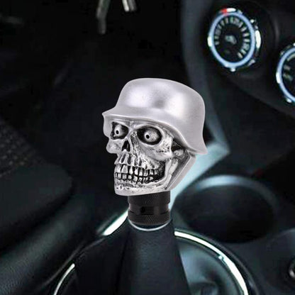 Skull-shaped silver gear shift knob with black textured base, front view.