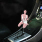 Car shift knob topper with brunette woman figure in white outfit on gear area
