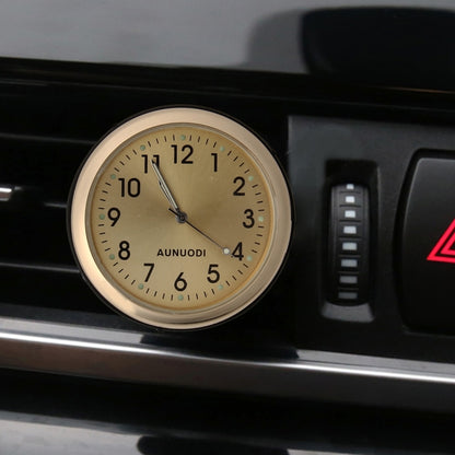 Gold car air-vent clock with beige dial and glowing minute markers