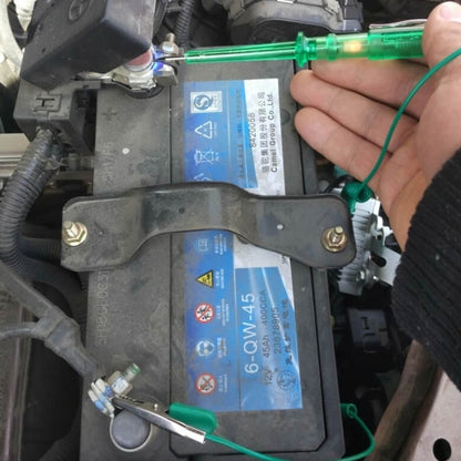 Green voltage detector pen with cable and crocodile clip in vehicle fuse box