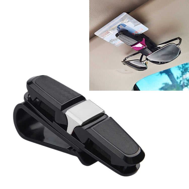 Black vehicle glasses clip with textured pads and spring clamp, close-up