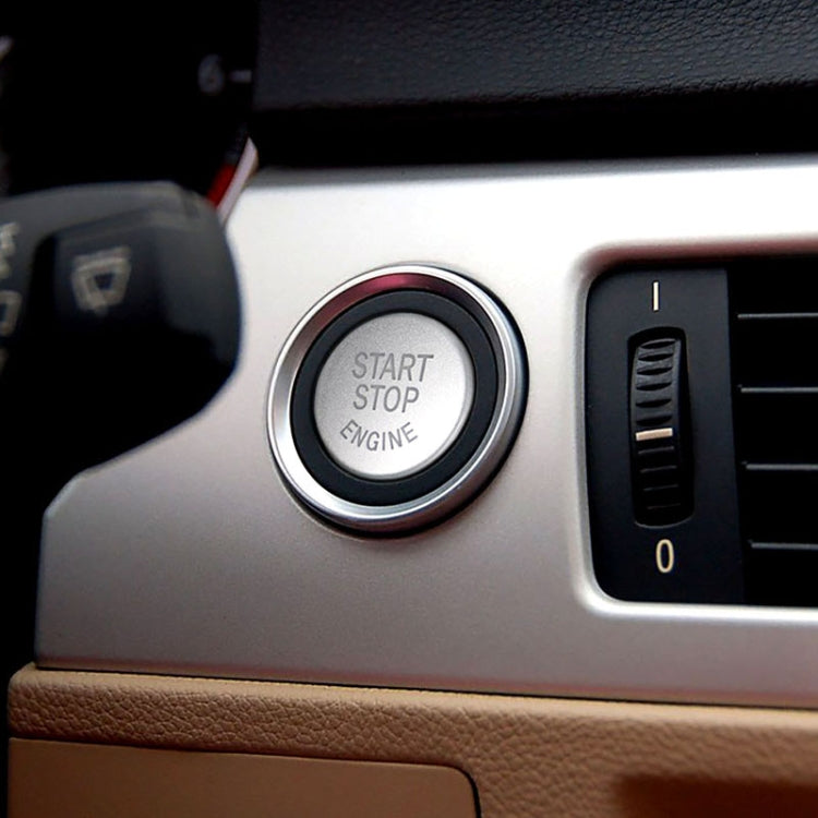 Black start-stop engine button cover with chrome rim in center console