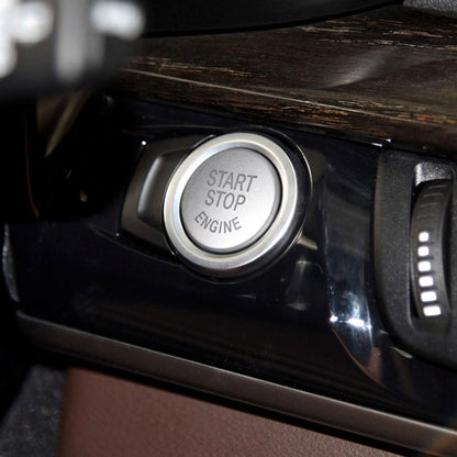 Silver push button cover with START STOP ENGINE text, mounted on dashboard panel