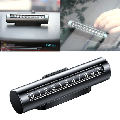 Black metal parking number roller card with digits 0–9, close-up on dashboard