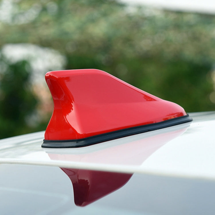 Shark fin car antenna aerial, red fin mounted on car roof.
