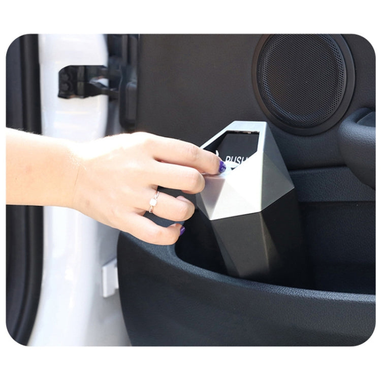 Hand using a mini push-lid trash can inside a car seat console