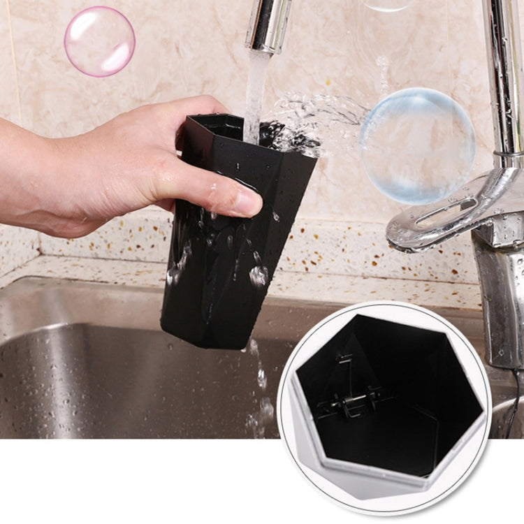 Black mini trash can with push lid placed near a kitchen sink; open-top shown