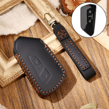 Black leather key fob cover with key ring and orange-stitched edges, molded icon panel