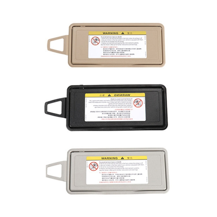 Right car sun visor makeup mirror in beige, black, and grey, warning label
