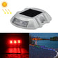 Solar road stud light with red LED glow, solar panel top, horseshoe design.