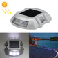 Solar road stud light with white LED glow, clear lens housing, horseshoe shape.