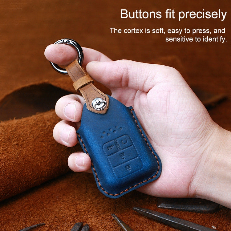 Blue cowhide leather key fob cover with key ring, embossed button icons, held in hand