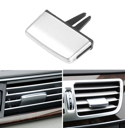 Silver A/C vent outlet tab clip with black mounting prongs, standalone close-up