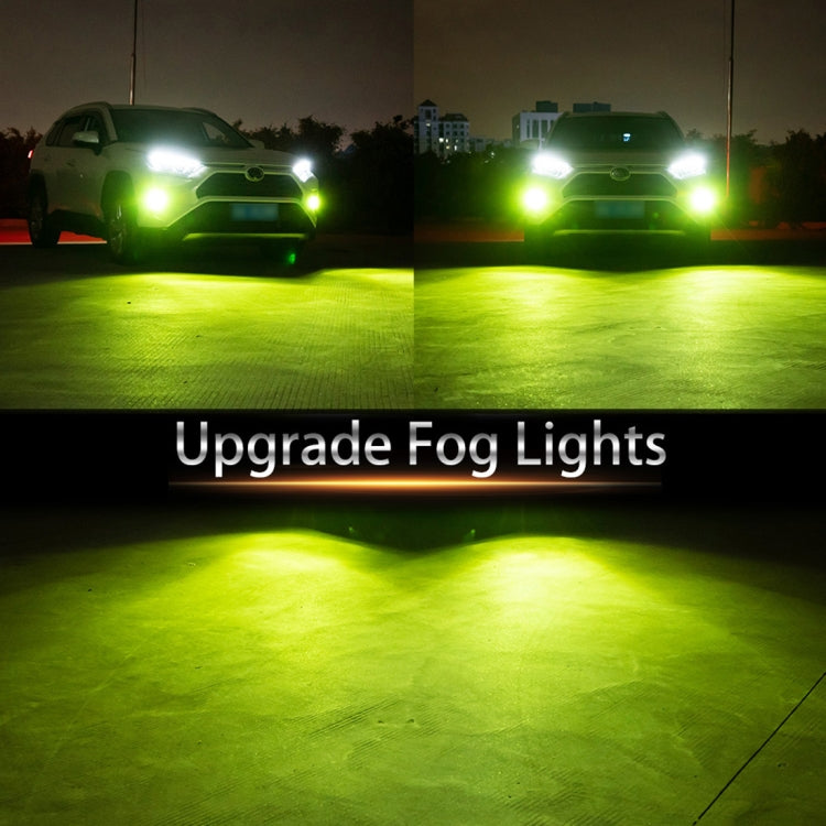 Car fog lights emitting green light beams from front bumper housings