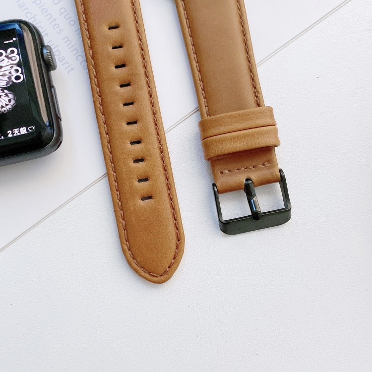 Tan leather watch band detail with rows of holes and metal buckle