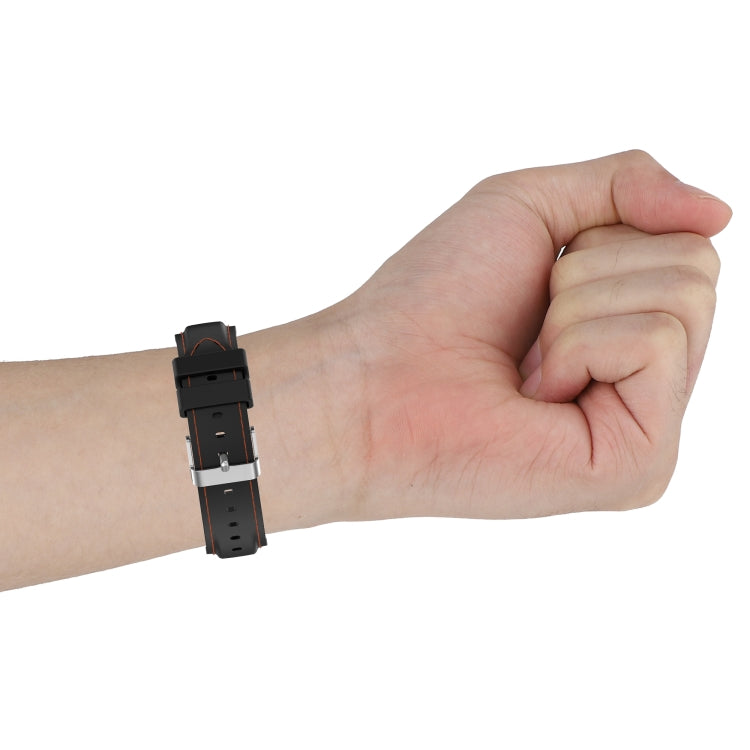 22mm silicone watch strap on wrist, black with orange edge stitching