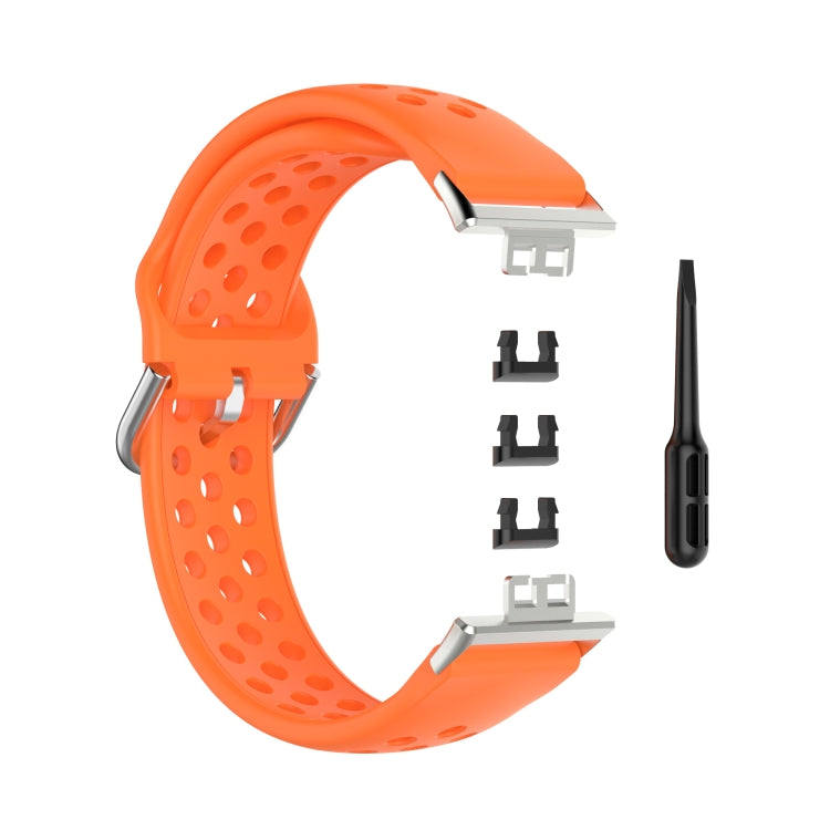 Orange perforated silicone watch strap with clasp, replacement adapters, and pin tool.