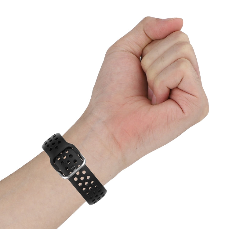 Black perforated silicone watch strap on wrist with metal buckle