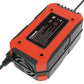 Orange battery charger with rear label panel and ventilation slots, black power cable