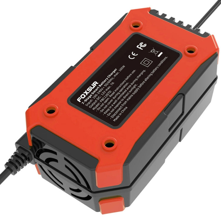 Orange battery charger with rear label panel and ventilation slots, black power cable