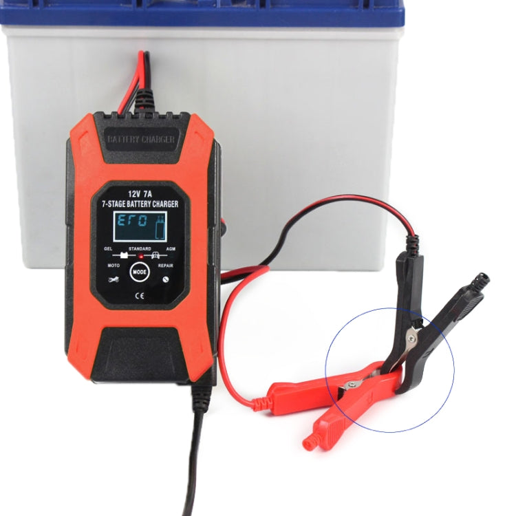 Orange 12V battery charger with alligator clips connected to a battery
