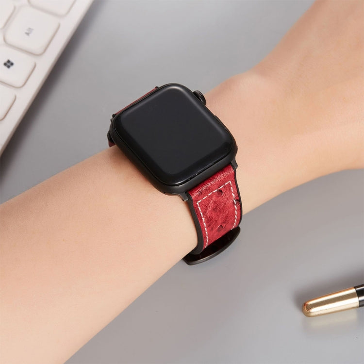 Ostrich-texture leather watch band, red strap with perforations and black buckle on wrist