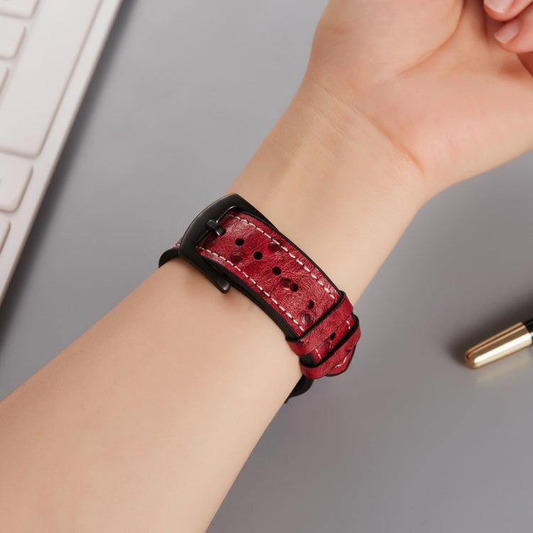 Ostrich-texture leather watch band with red perforated strap and black buckle close-up