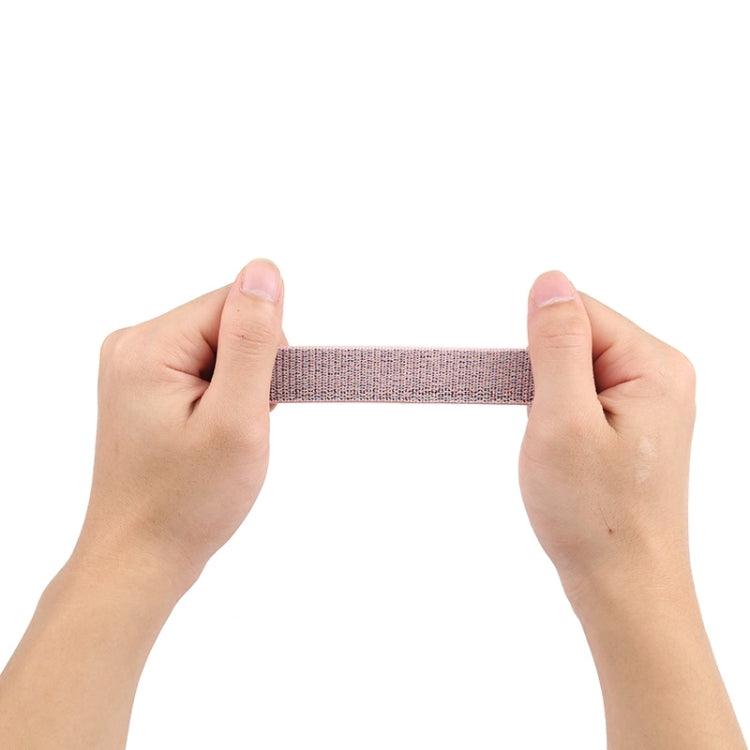 Light pink woven nylon watch band, held between hands
