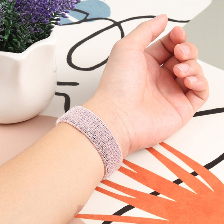 Light pink woven nylon watch band on a wrist