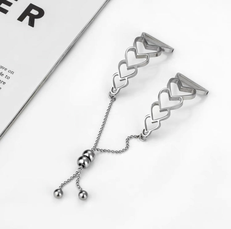 Silver heart-link watchband bracelet with chain and three dangling beads.
