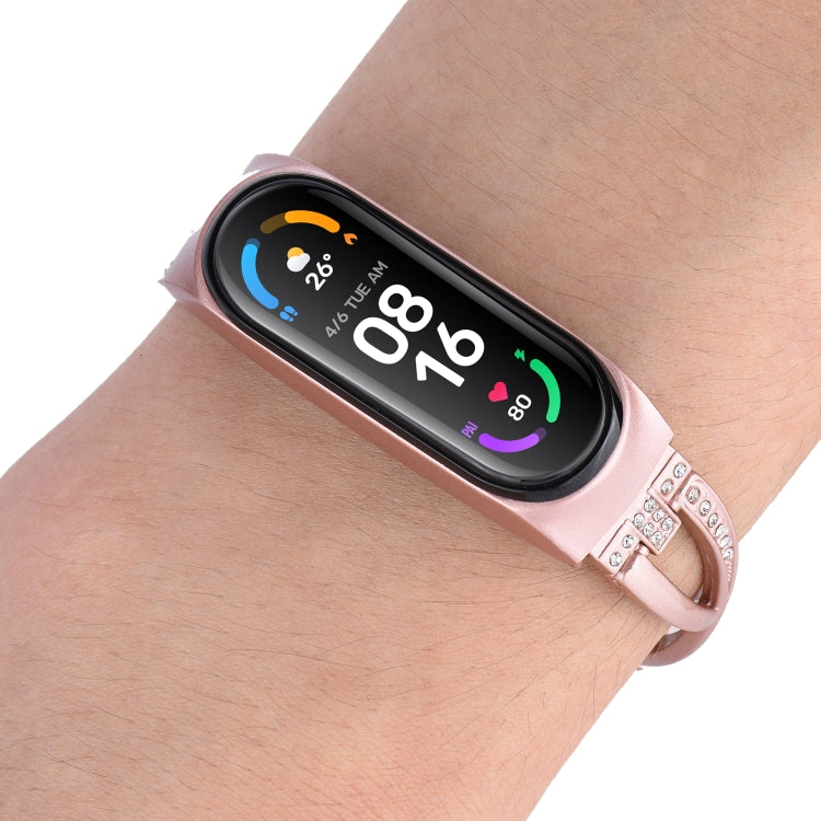 Rose gold replacement watch band with X-shaped metal links and rhinestone strap trim