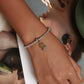 Sunflower charm bracelet on wrist with silver mesh band and green enamel leaf accents