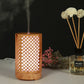 Wooden essential oil humidifier with light lattice cutouts, warm LED glow, mist vapor
