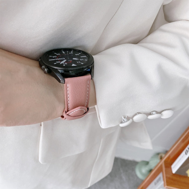 Rose pink leather watch strap with metal clasp and white stitching detail, on a wrist.