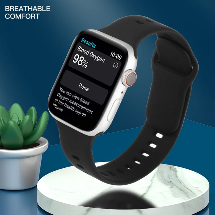 Black liquid silicone watchband on an Apple Watch, showing buckle and perforation holes.