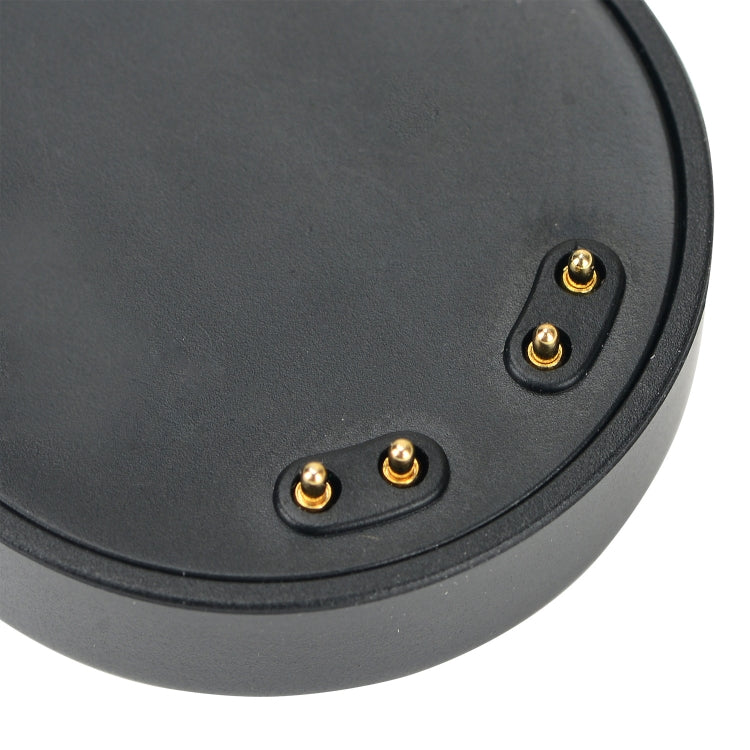 Black round charging puck with three gold contact pins for smartwatch charging