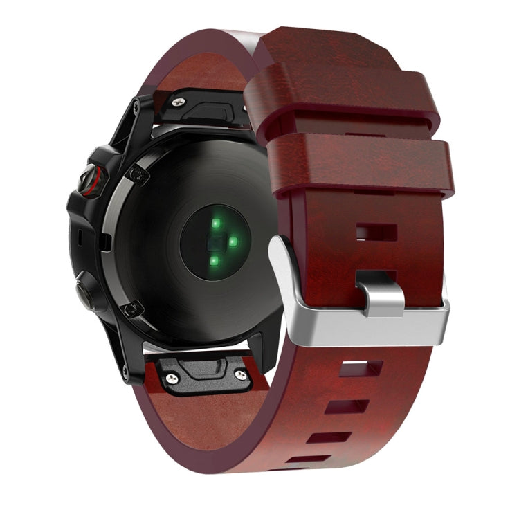 Burgundy leather quick-release strap holding a dark watch case with clasp underside